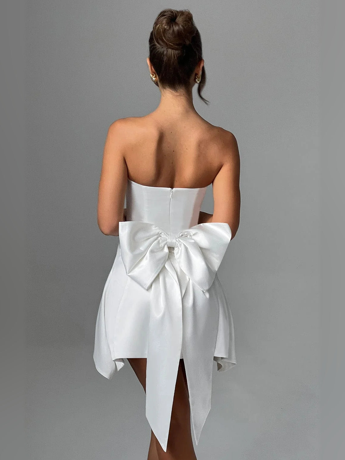 Ivory strapless mini dress, back view, with draped bow and cascading side panels