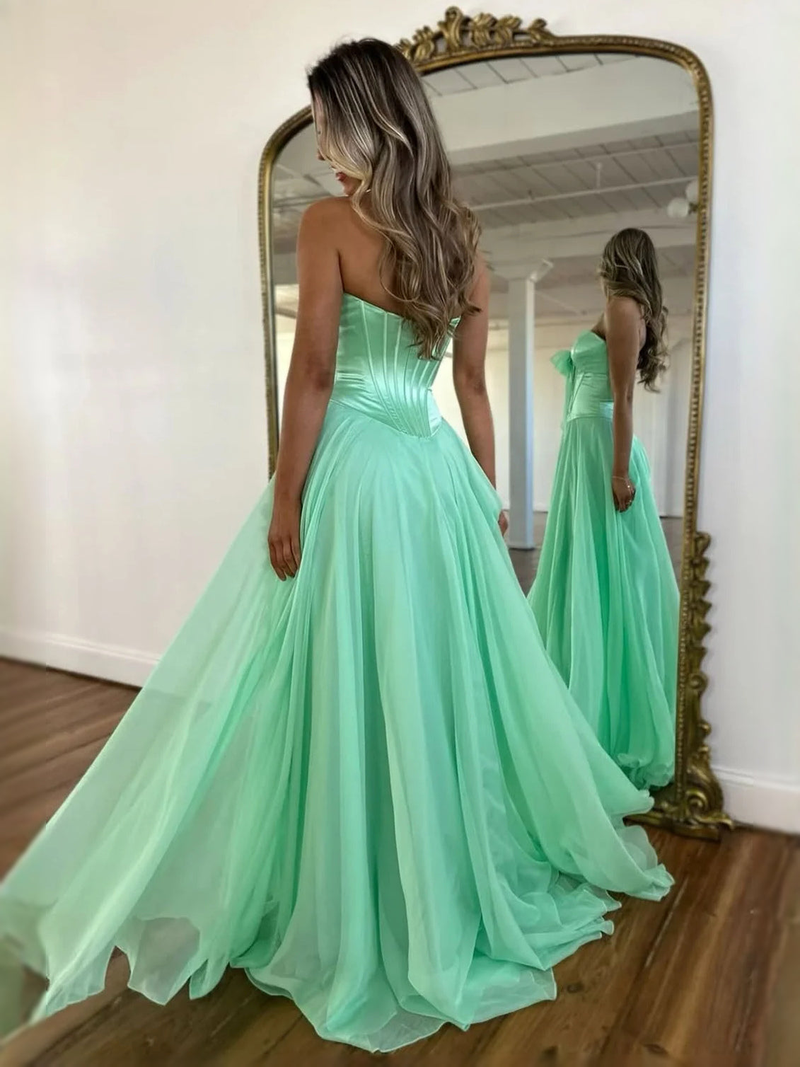Mint green strapless A-line prom dress from back, corset bodice and gathered skirt