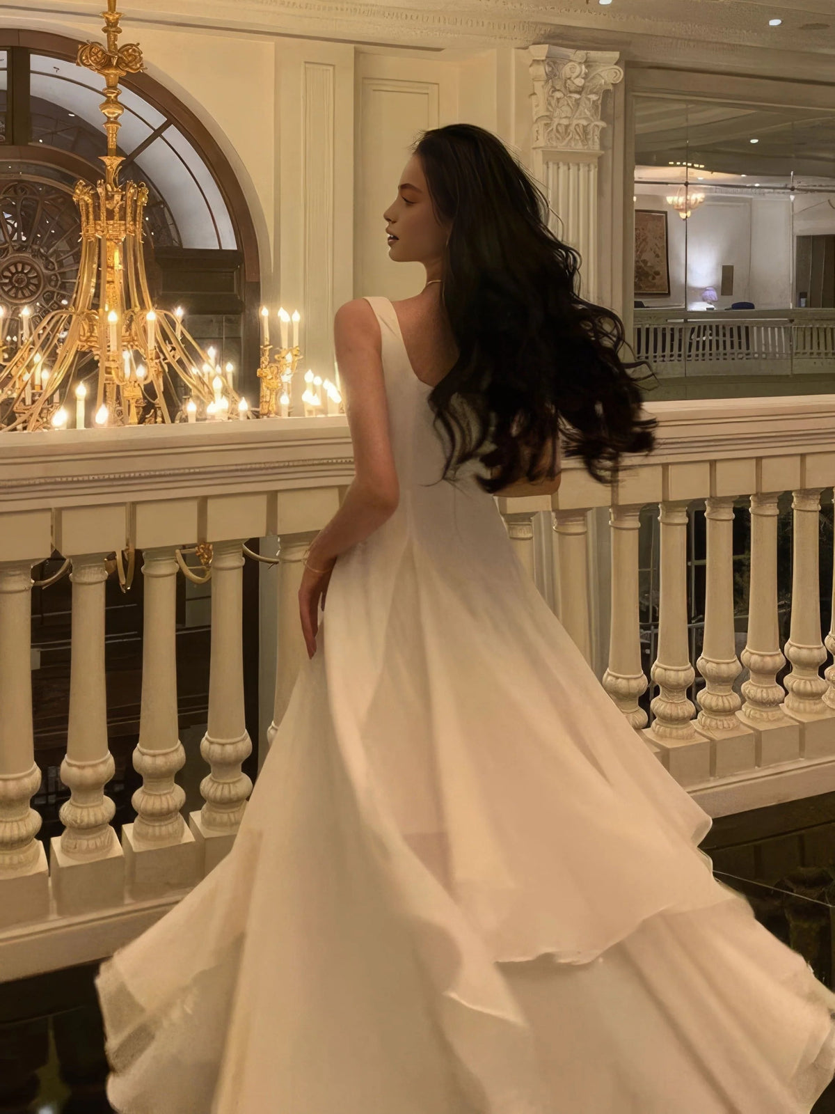 Ivory square-neck A-line wedding dress from back view, layered skirt panels, sleeveless