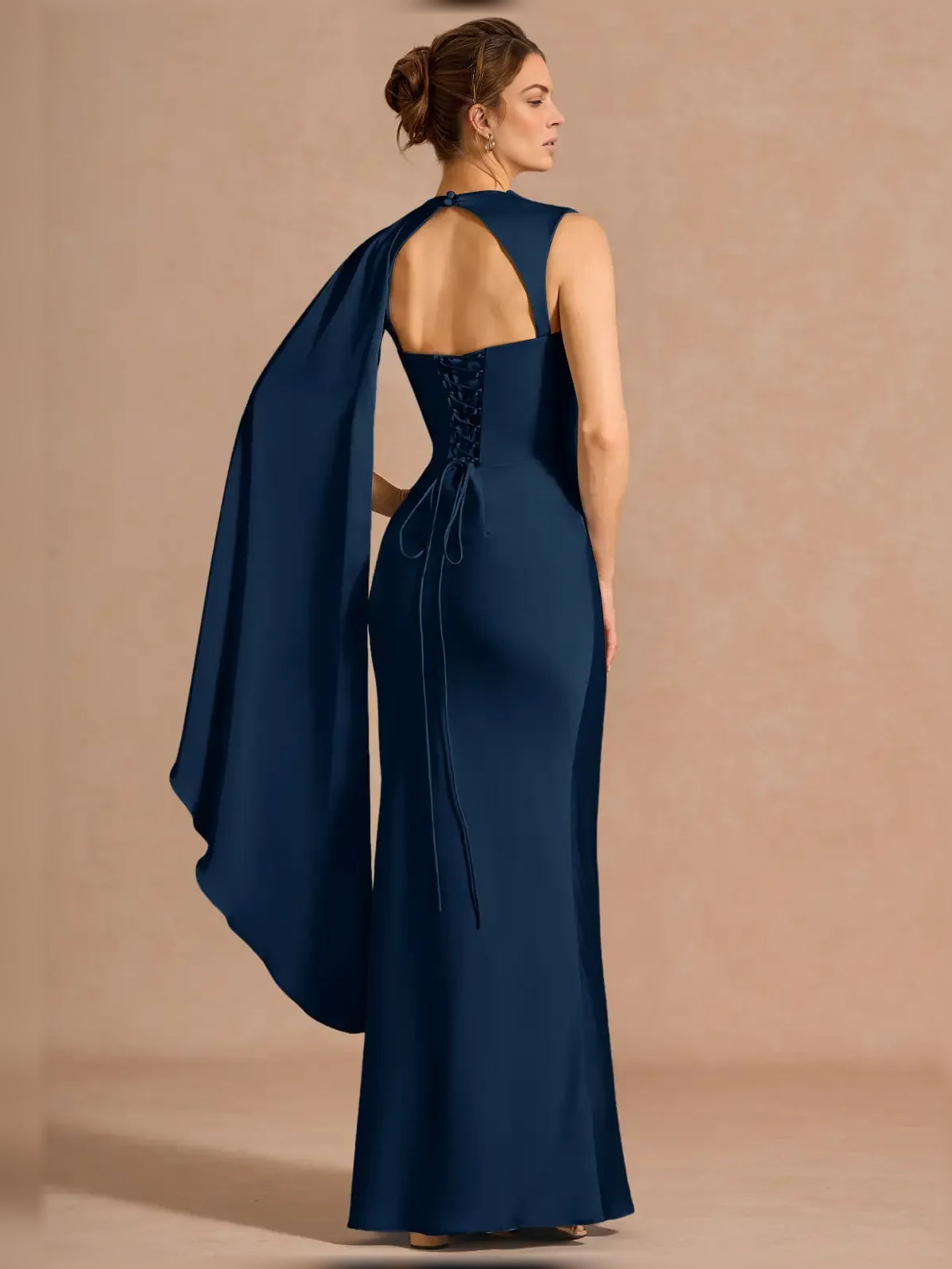Navy one-shoulder formal dress with open back and flowing draped cape panel