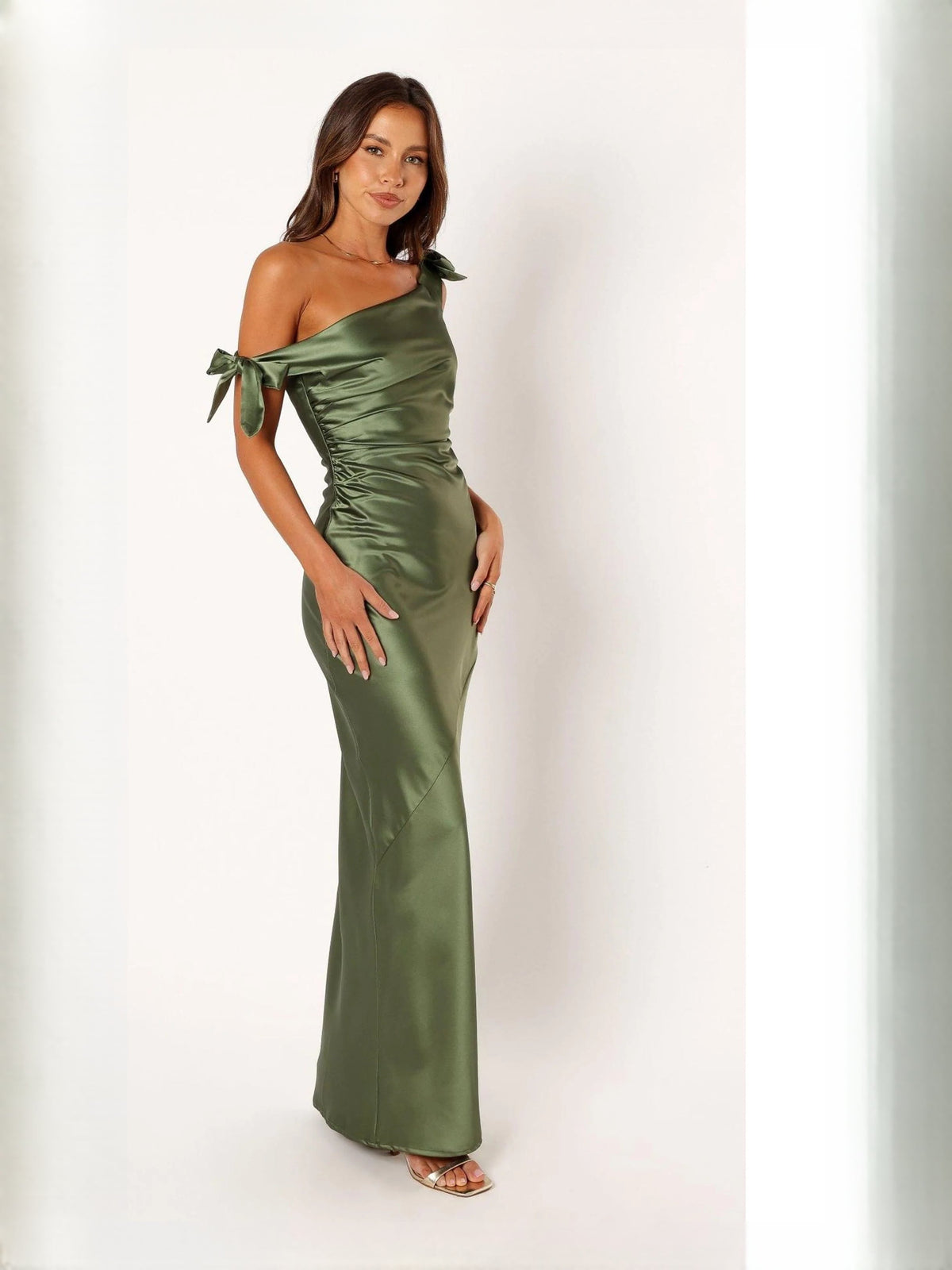 Sage green one-shoulder satin mermaid gown with bow straps and ruched waist