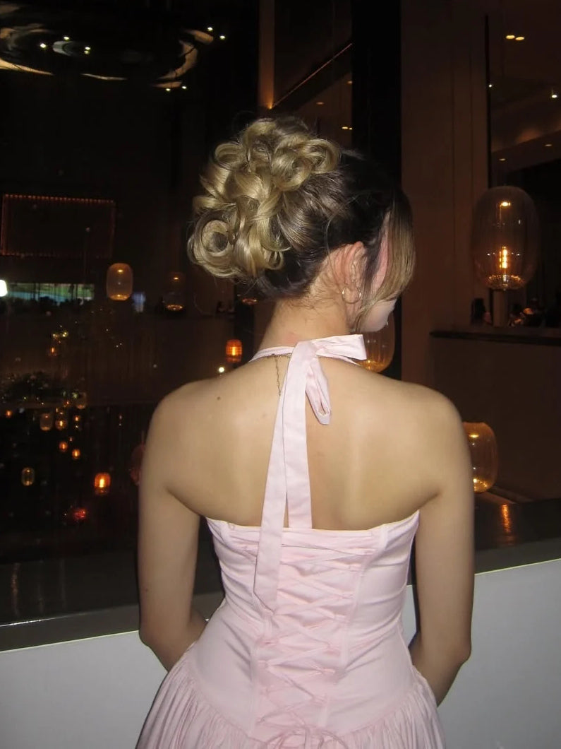 Blush pink corset sweetheart prom gown, open back with halter straps and tiered skirt