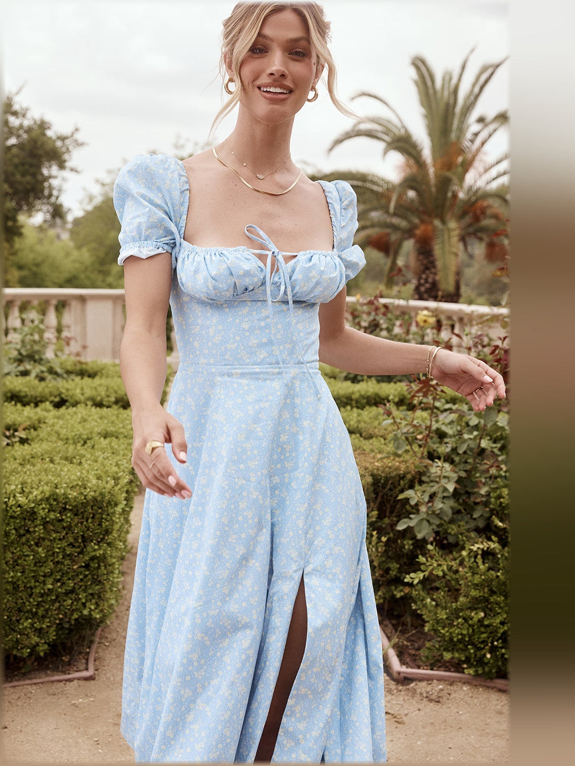 Light blue floral midi dress with gathered square neckline, puff sleeves, and tie detail