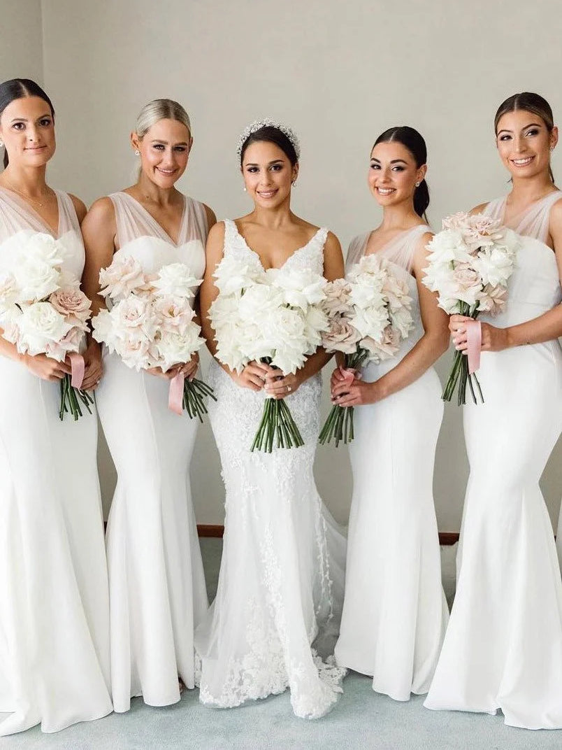 White sleeveless maxi dresses with V-neck bodice worn by bridesmaids