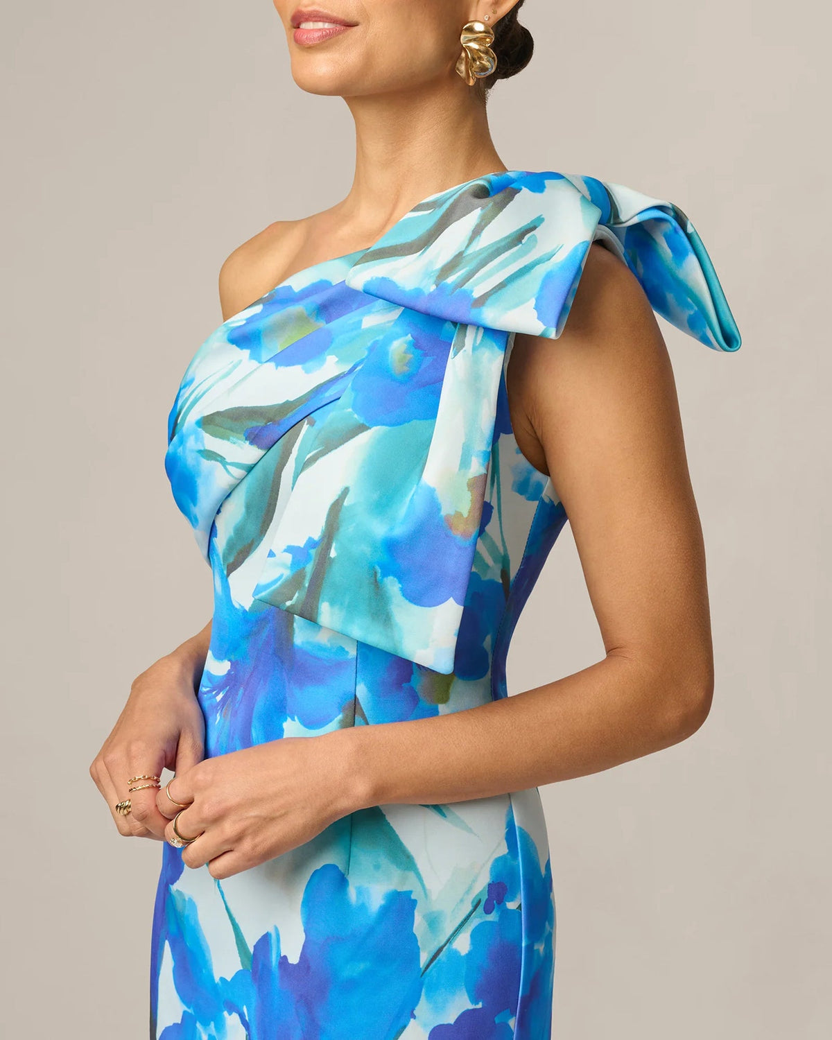 Blue floral one-shoulder maxi dress with draped bow overlay at neckline