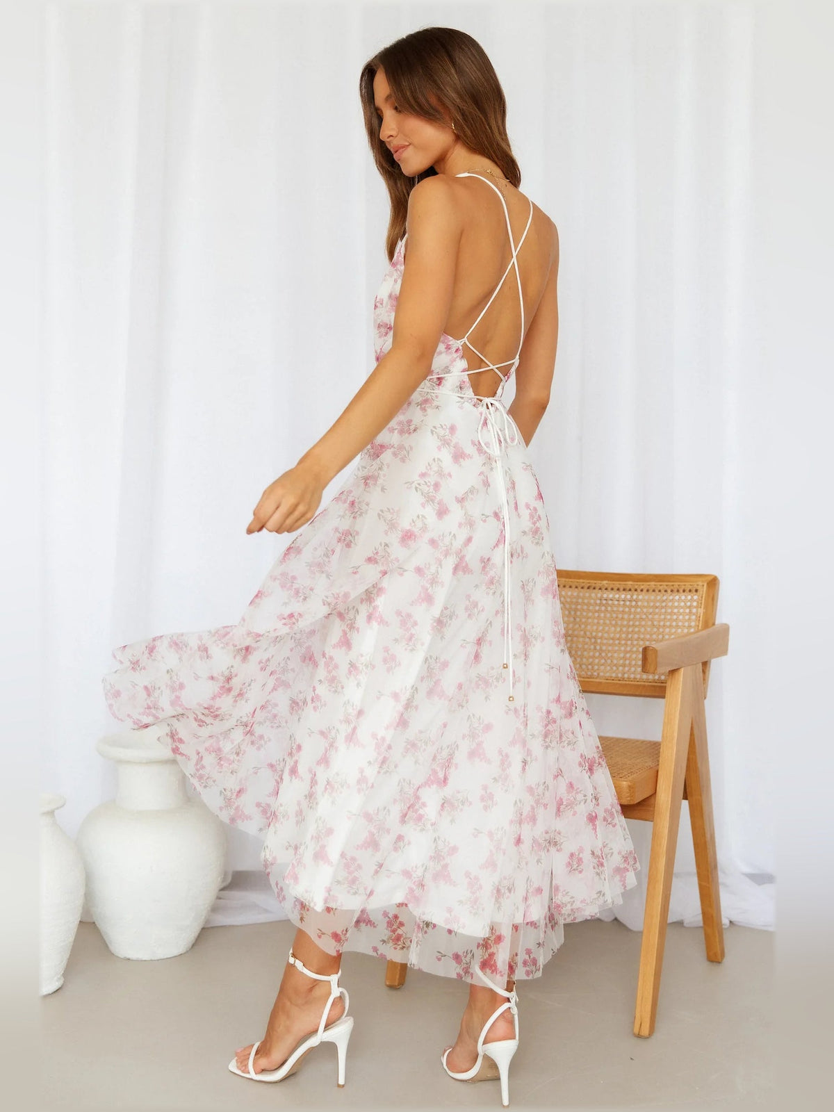 Pink floral midi dress with open back, crisscross spaghetti straps, tiered skirt
