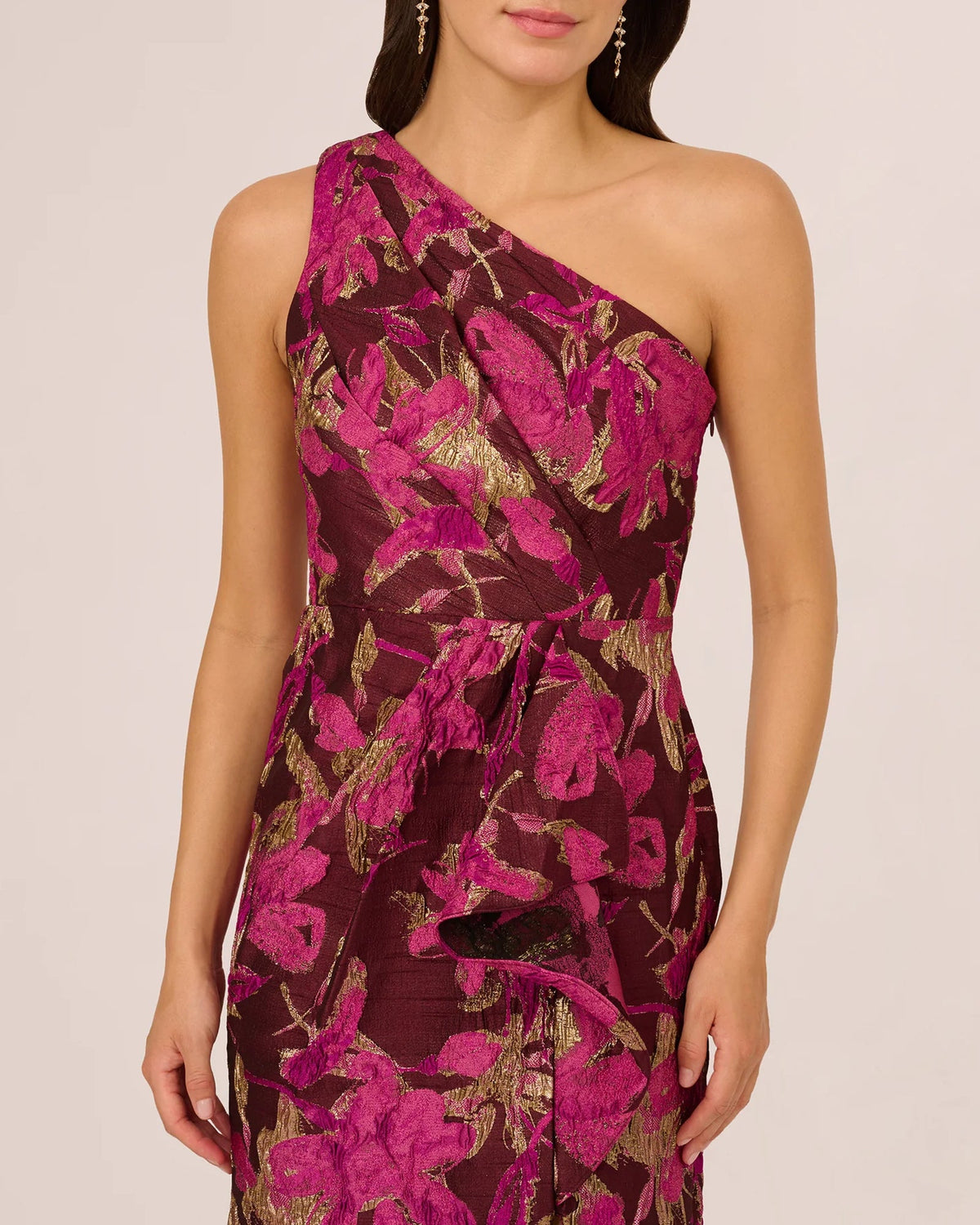 One-shoulder maxi dress close-up with burgundy botanical print and gold accents