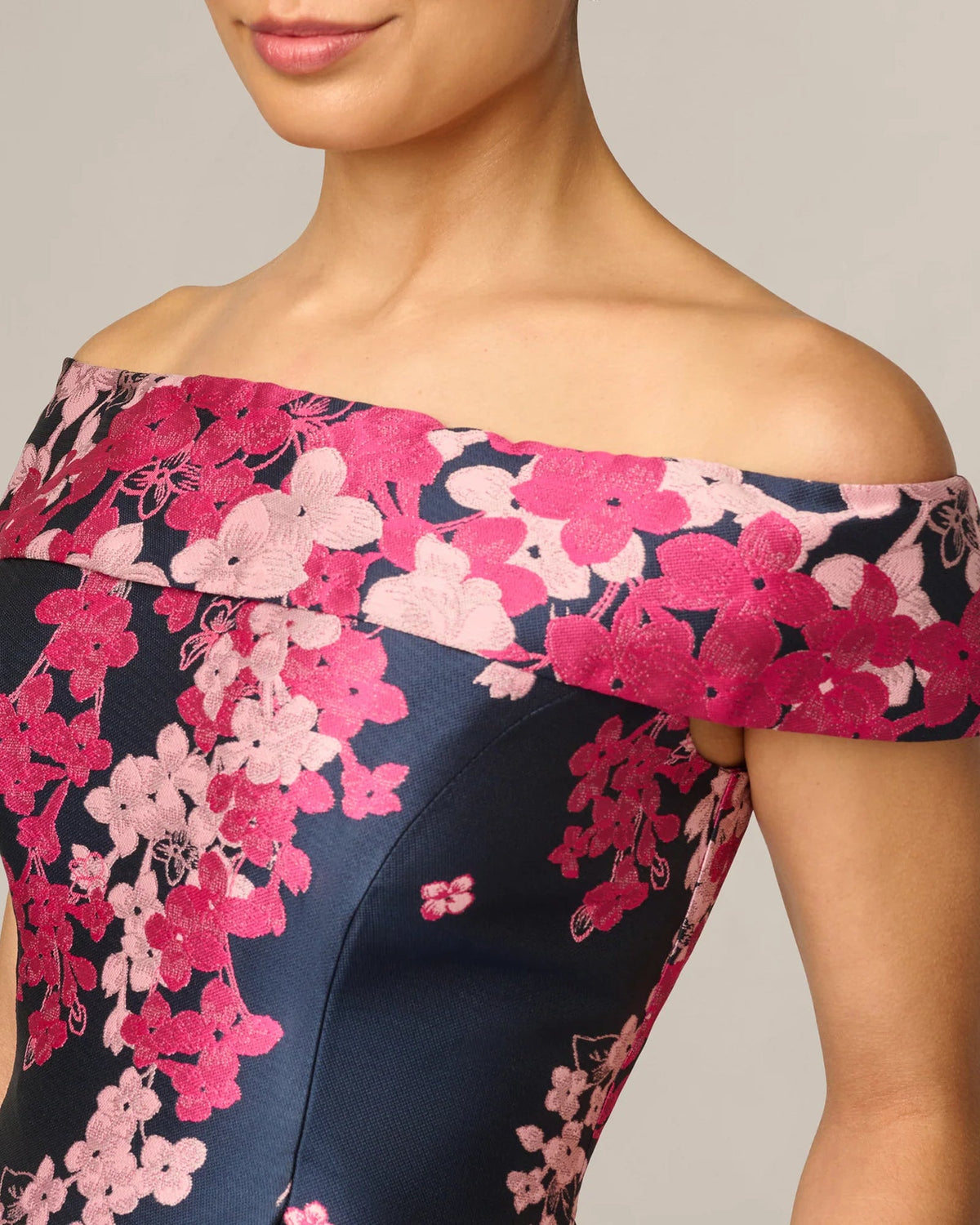 Close-up of off-shoulder neckline with pink floral embroidery on navy dress