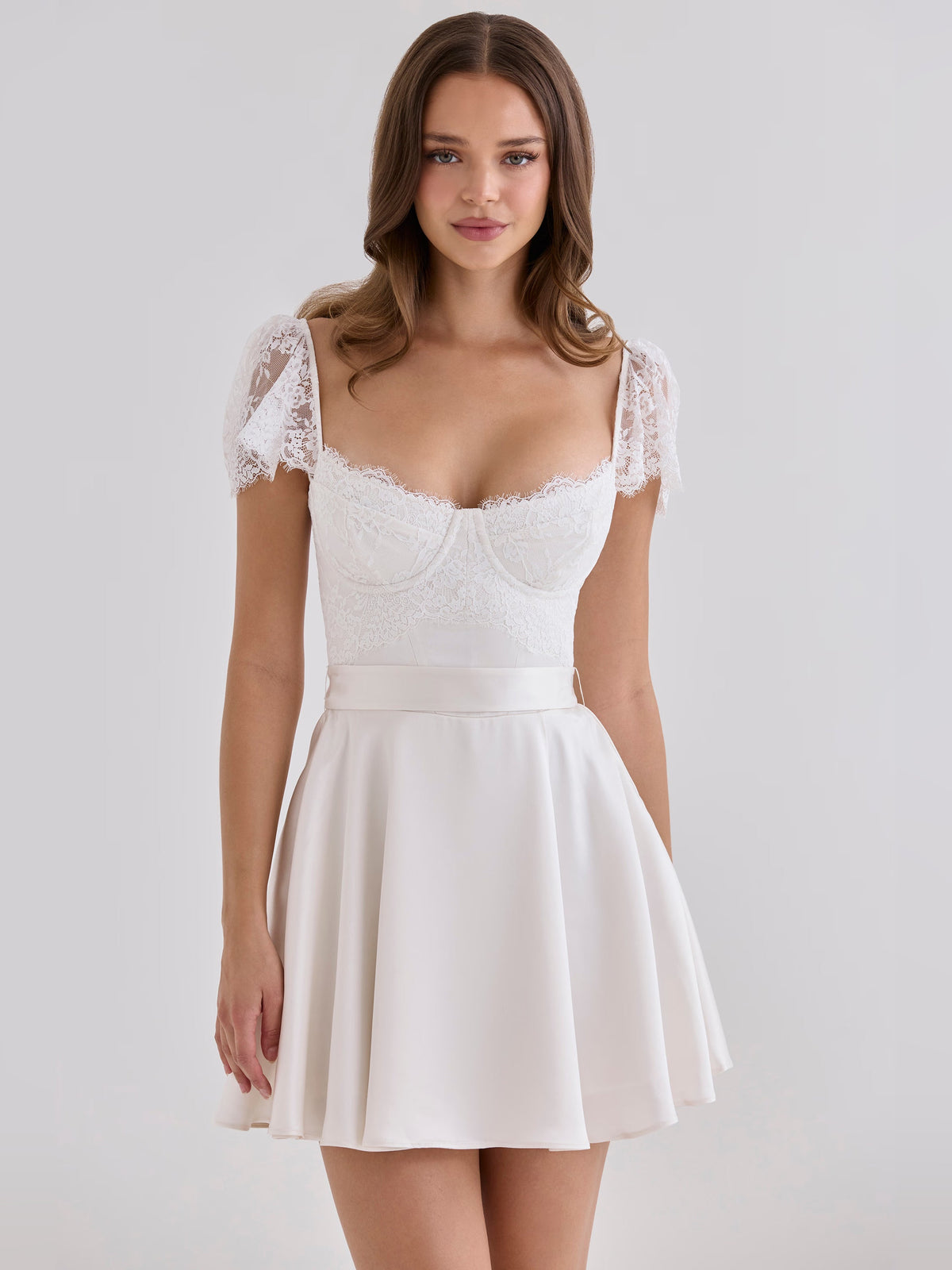 White mini satin homecoming dress with lace short sleeves, fitted bodice, and flared skirt