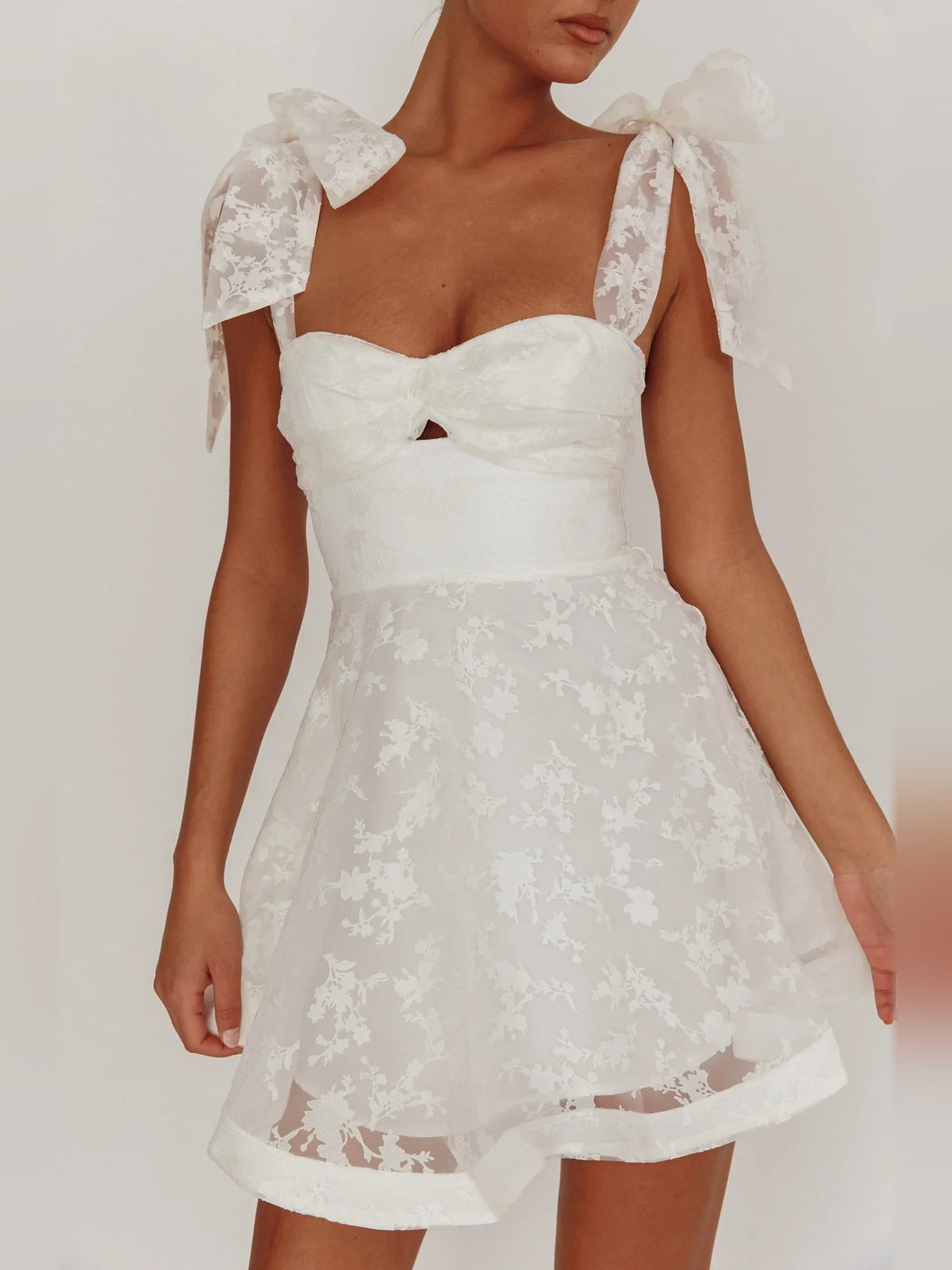 Ivory sweetheart mini dress with bow shoulder sleeves and layered organza floral hem