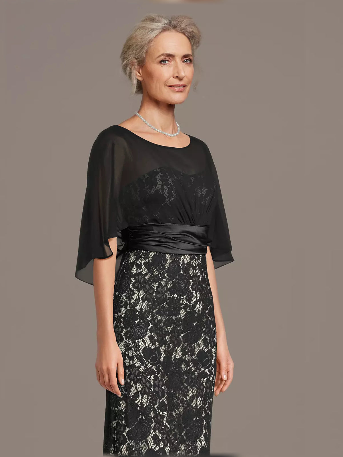Black lace mermaid maxi dress with bateau neckline, sheer sleeves, and ruched satin band