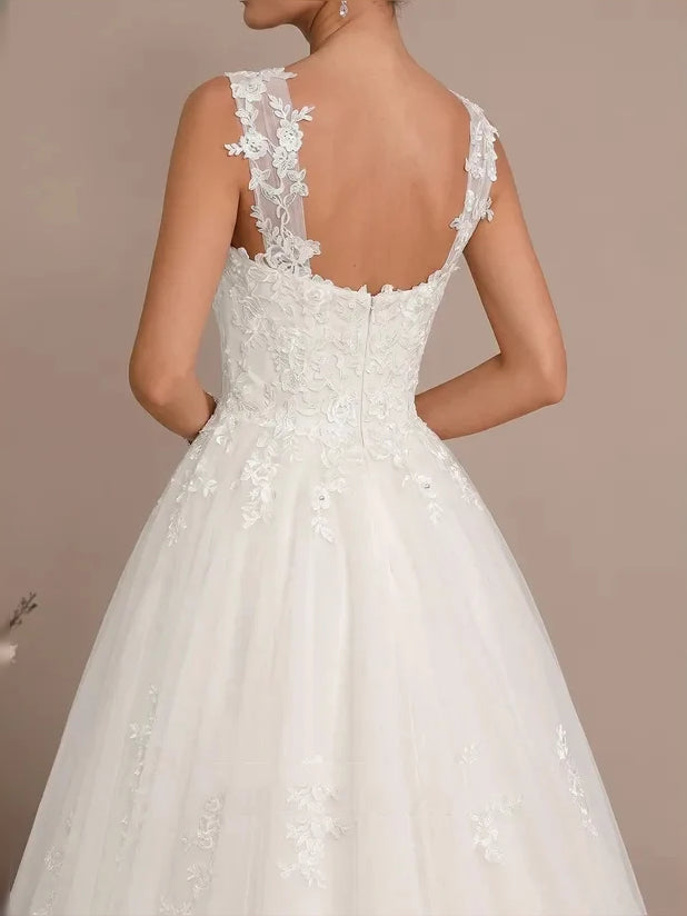 Back view of ivory lace tulle mini wedding dress with floral appliques and V-shaped back