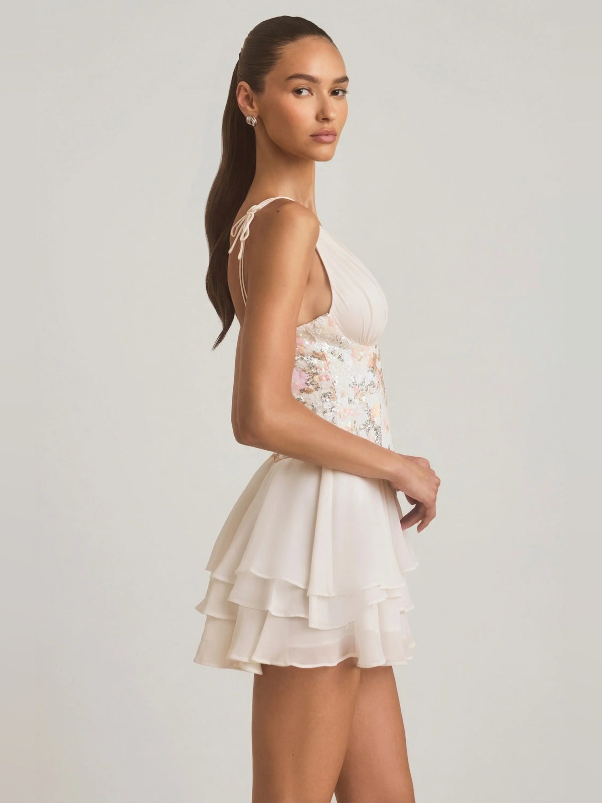 Ivory corset mini dress in side view with floral bodice panel and layered ruffles