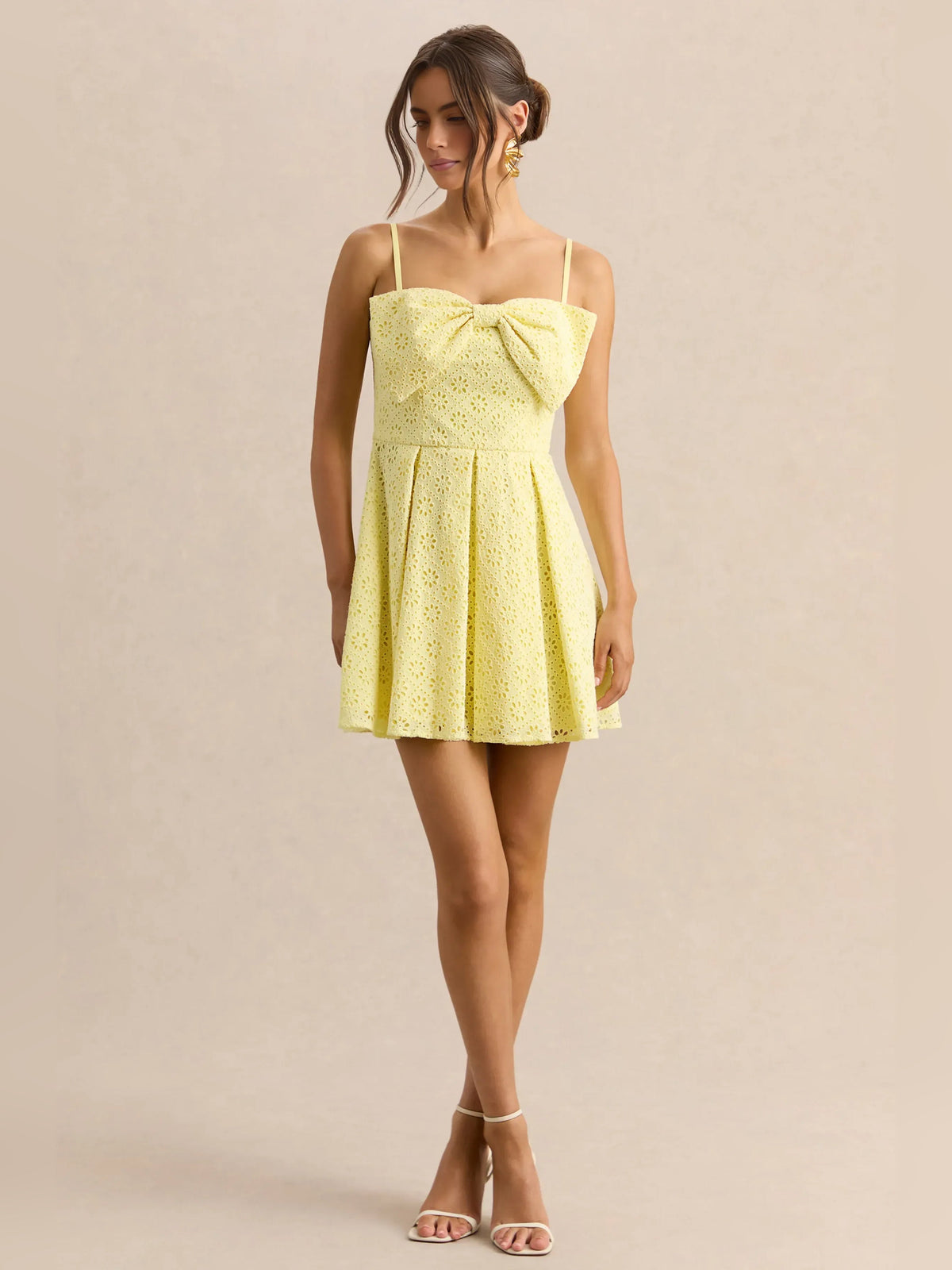Lemon yellow eyelet mini homecoming dress with sweetheart neckline, bow detail, and straps