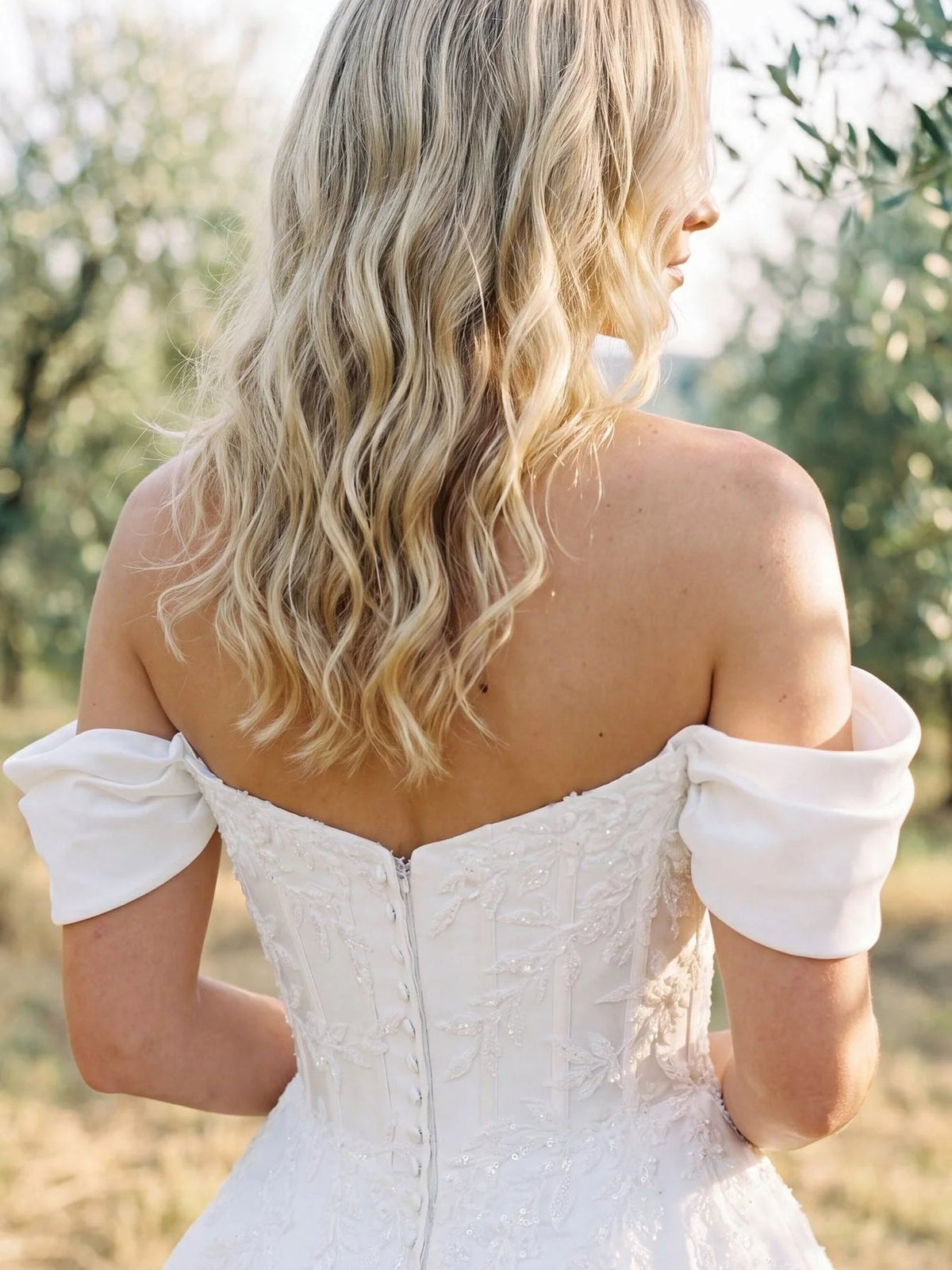 Ivory off-shoulder satin wedding dress with corset back and button detail