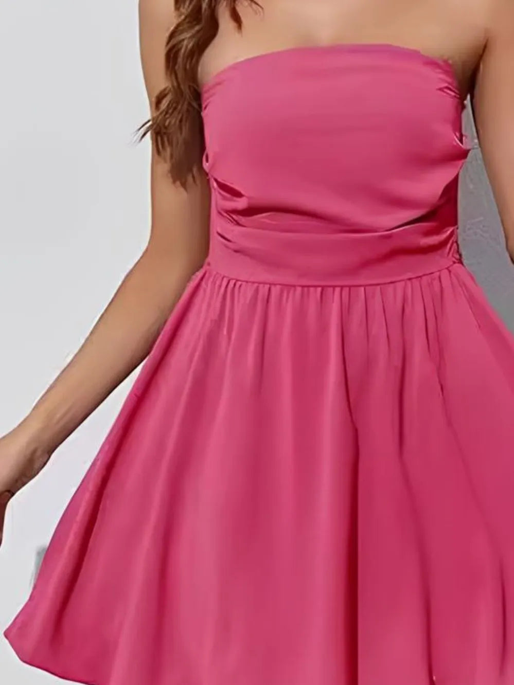 Pink strapless ruched bodice mini dress with gathered waist and pleated skirt