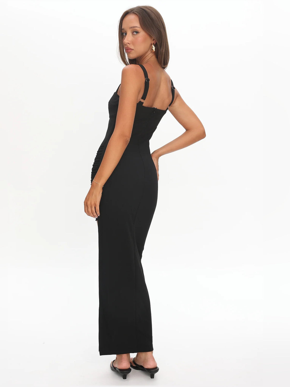 Black sleeveless midi formal dress with fitted silhouette and front slit, side angle