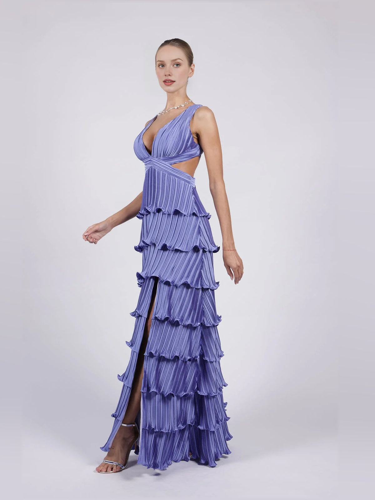 Purple v-neck pleated tiered formal dress with side slit and layered ruffle tiers.