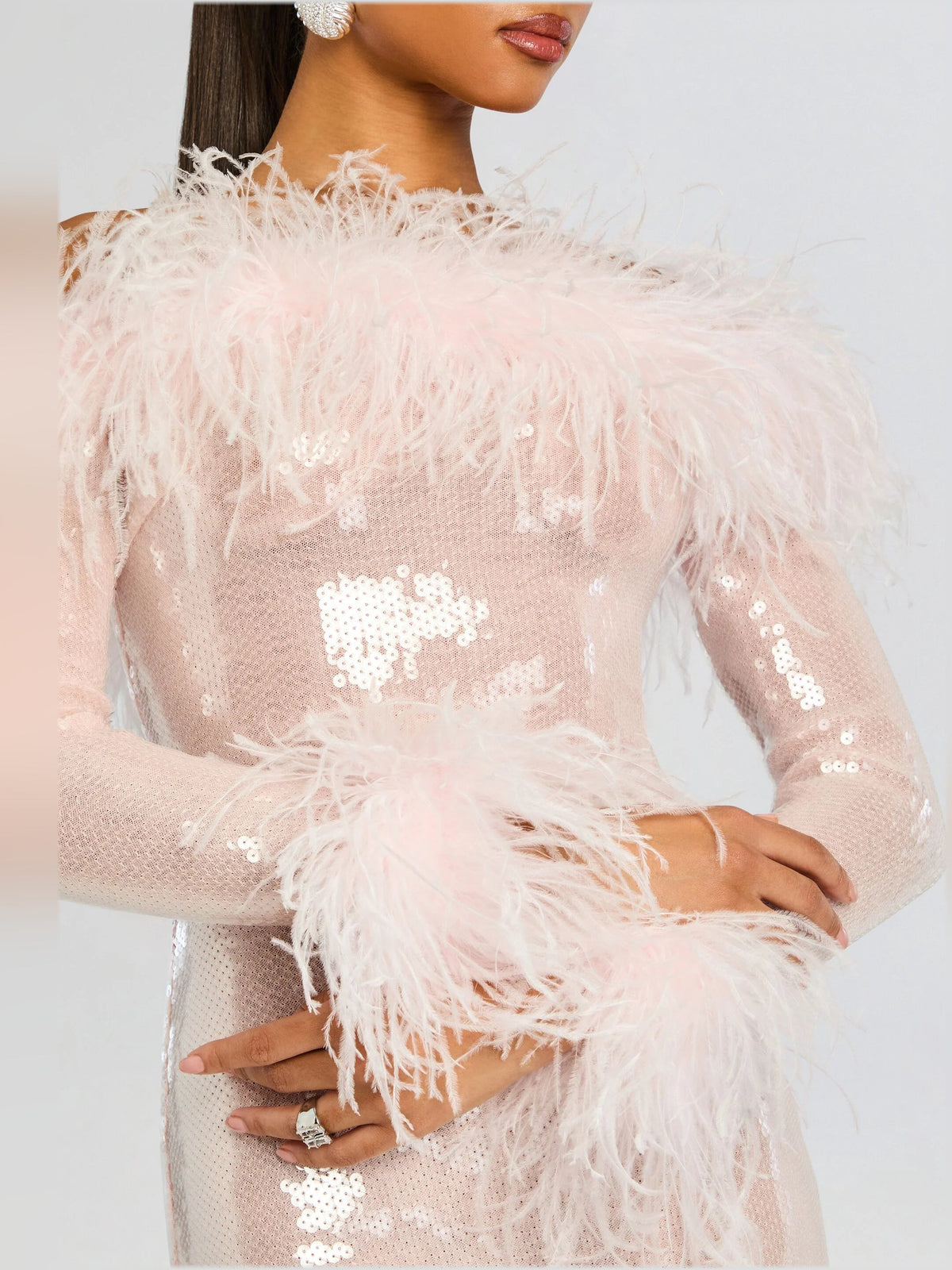 Pink sequin midi dress with feathered neckline and long sheer sleeves, close-up