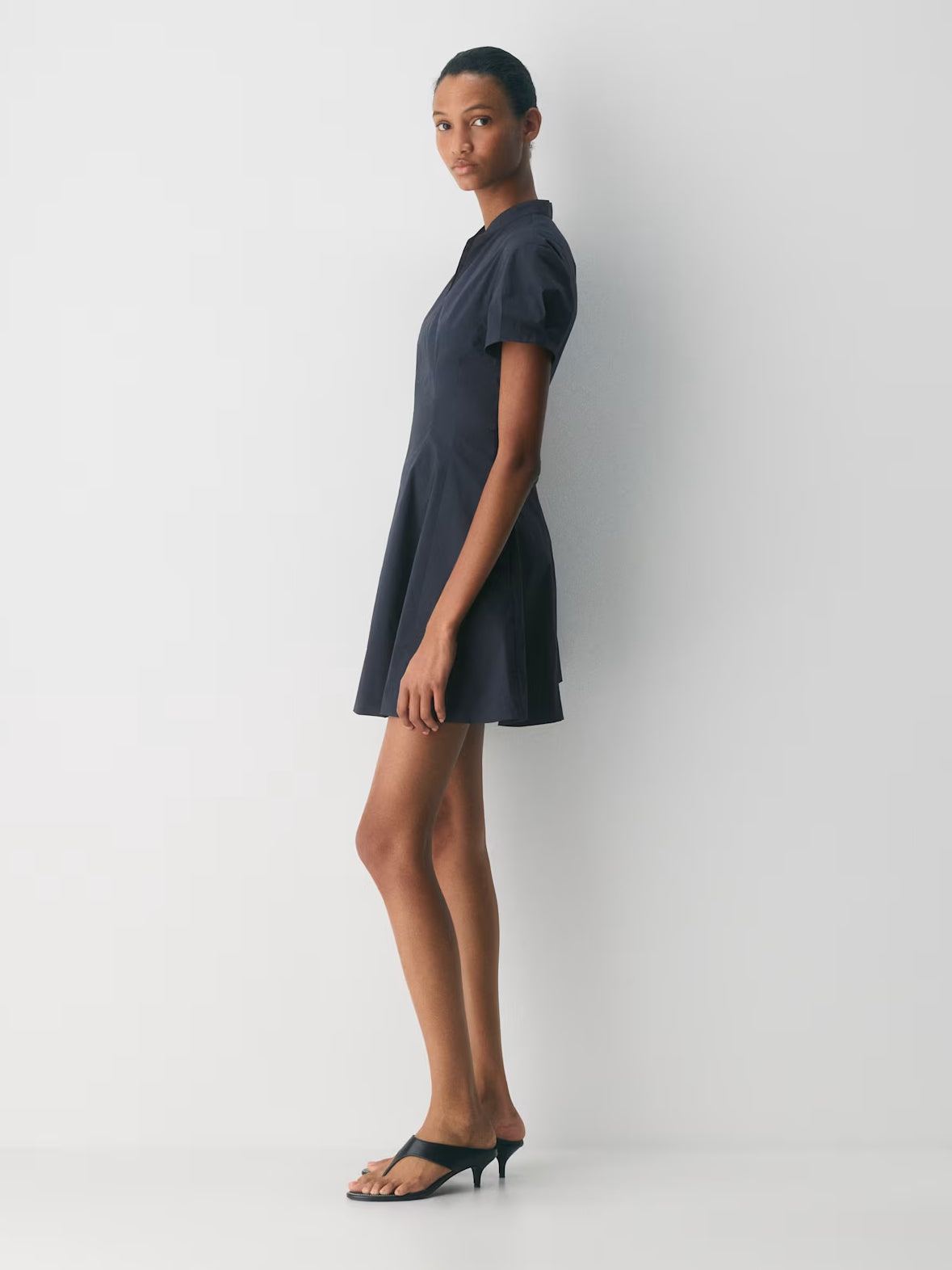 Dark navy A-line mini dress with short sleeves and high neck, side view