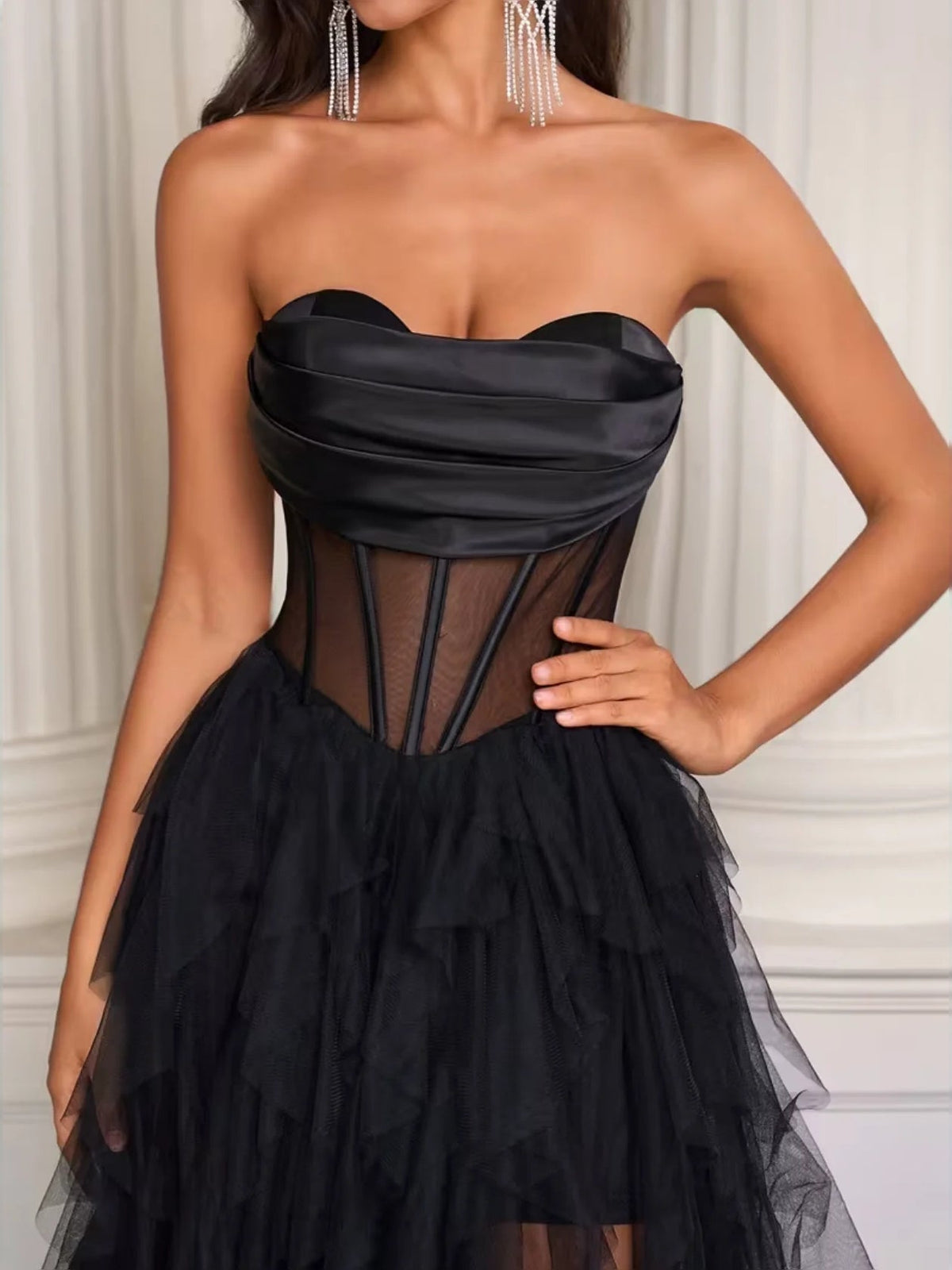 Black corset-style strapless bodice with sheer paneling and tiered tulle skirt, floor-length