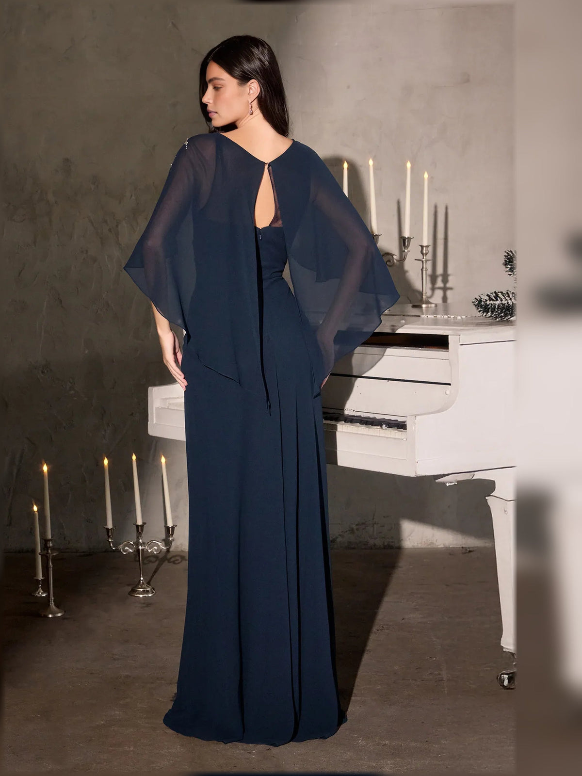 Navy floor-length column dress with sheer cape sleeves and beaded scoop neckline