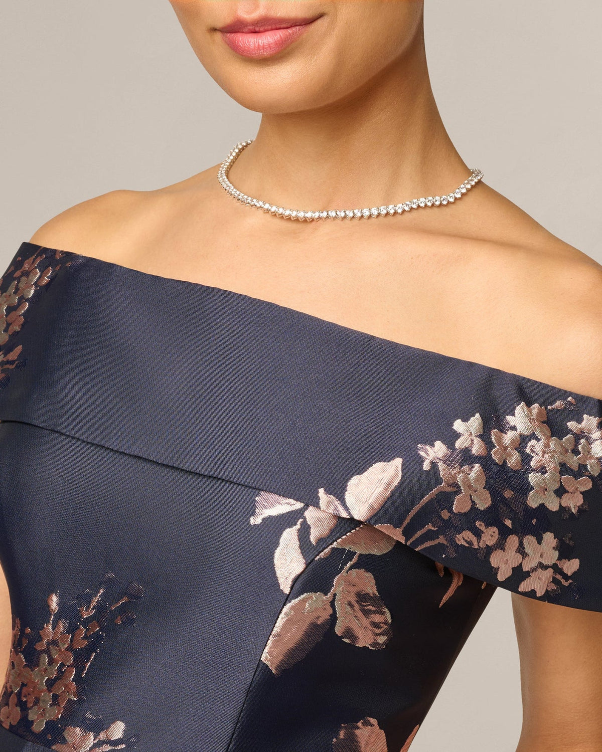 Off-shoulder navy dress with blush floral print and beaded necklace
