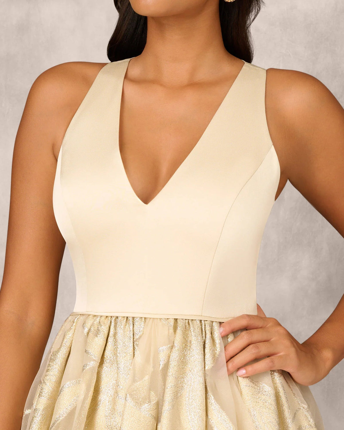 Gold V-neck sleeveless bodice with gathered waist and beaded skirt on a mother-of-the-bride gown