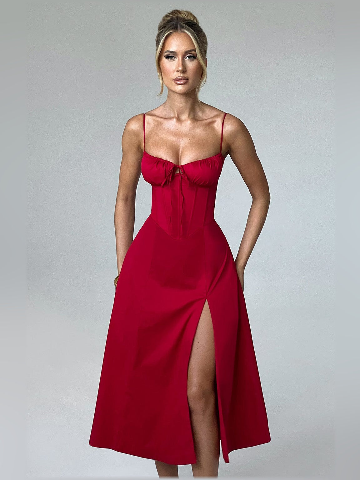 Red midi formal dress featuring spaghetti straps, ruched bust, and front slit skirt