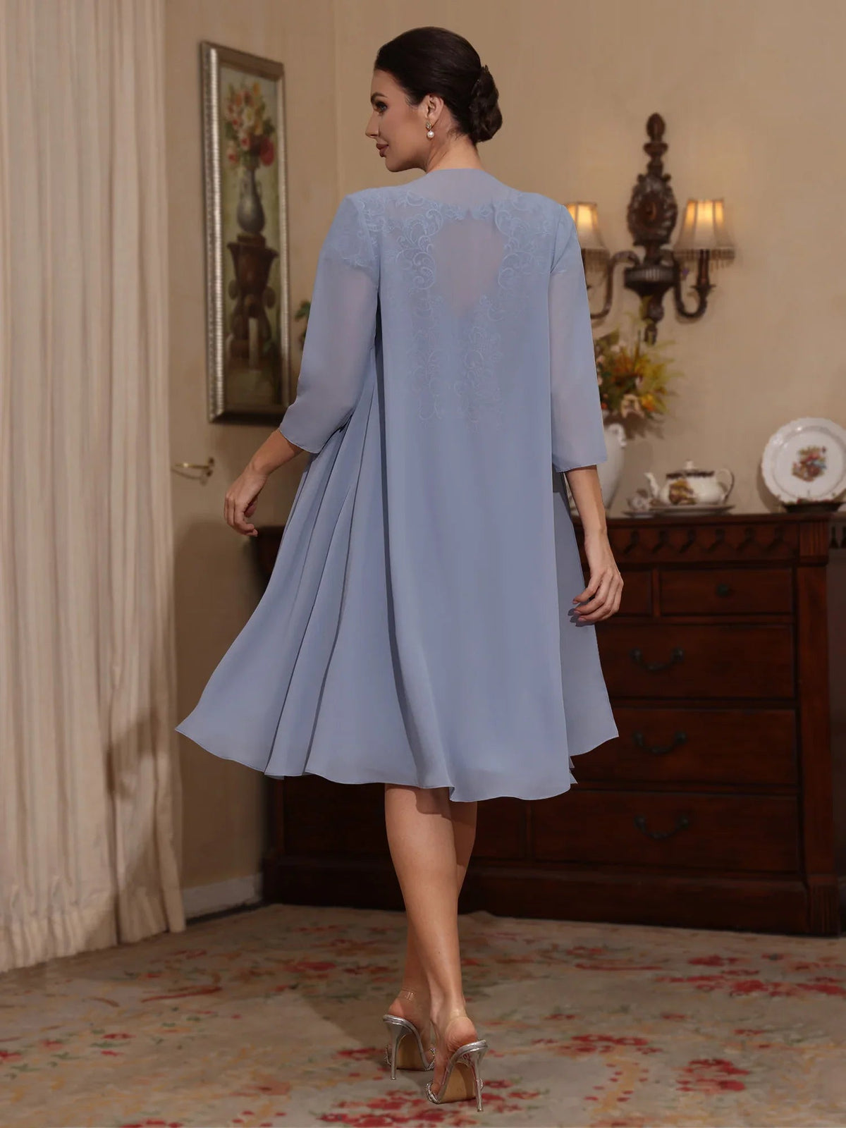 Dusty blue chiffon knee-length dress, back view with smooth shoulders and flared hem