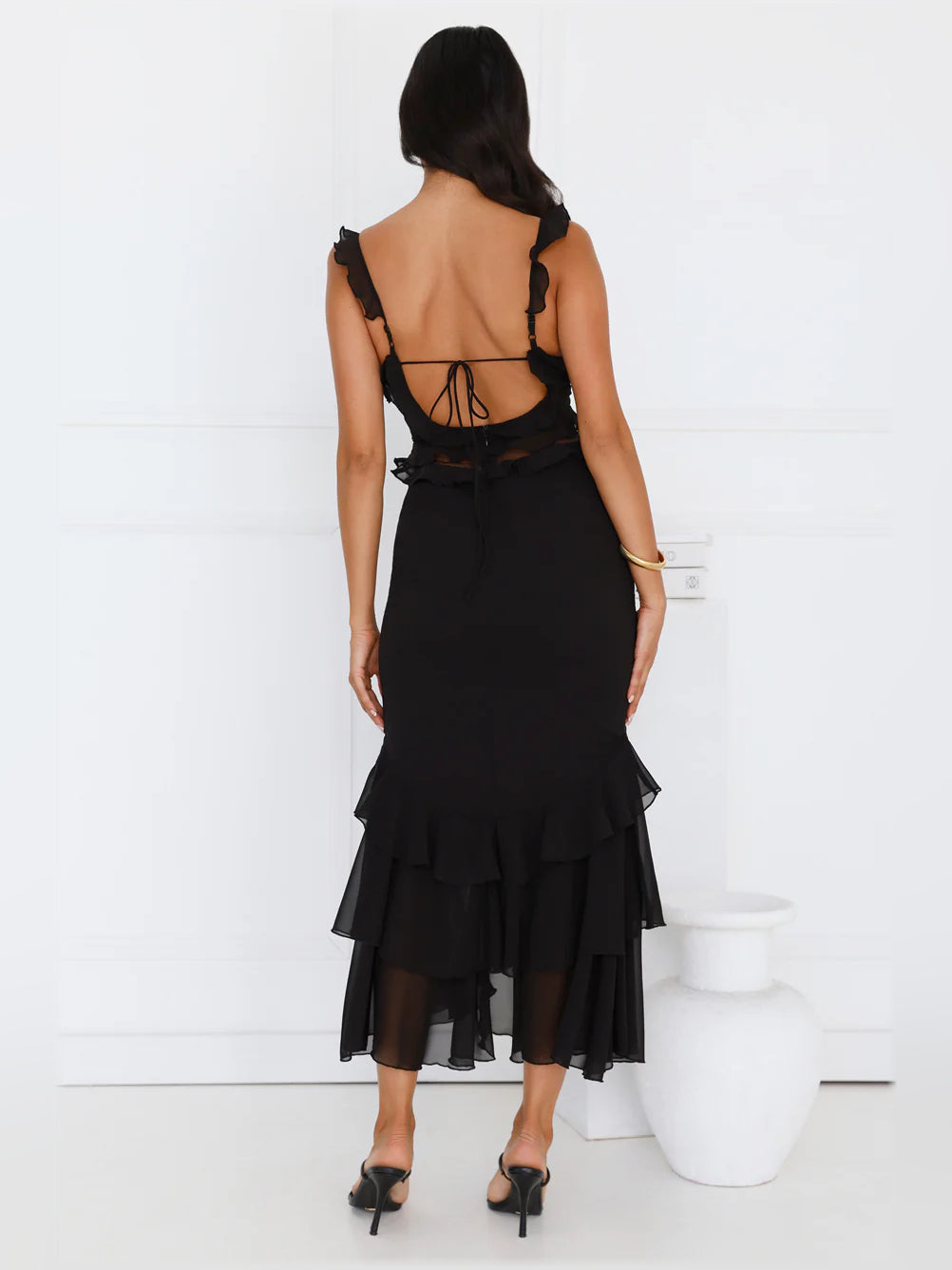 Back view of black midi formal dress with open-back straps and tiered ruffles