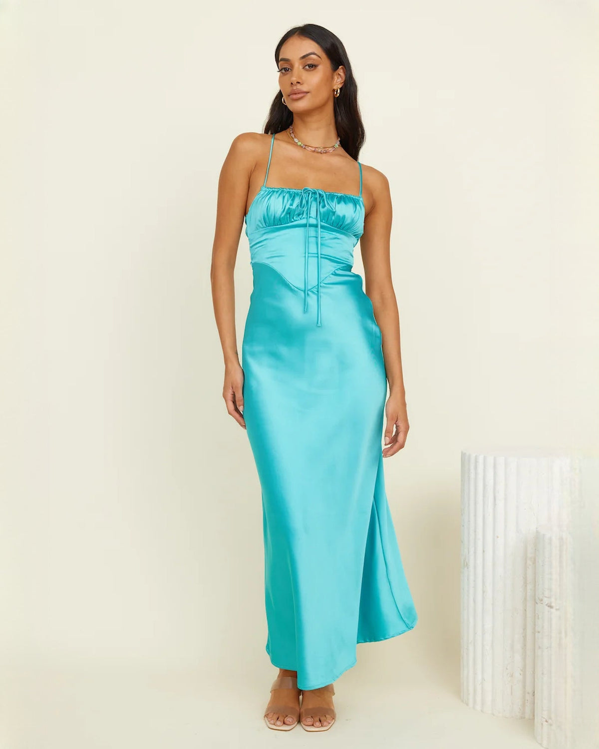 Aqua satin sleeveless maxi dress shown from the side with ruched bust