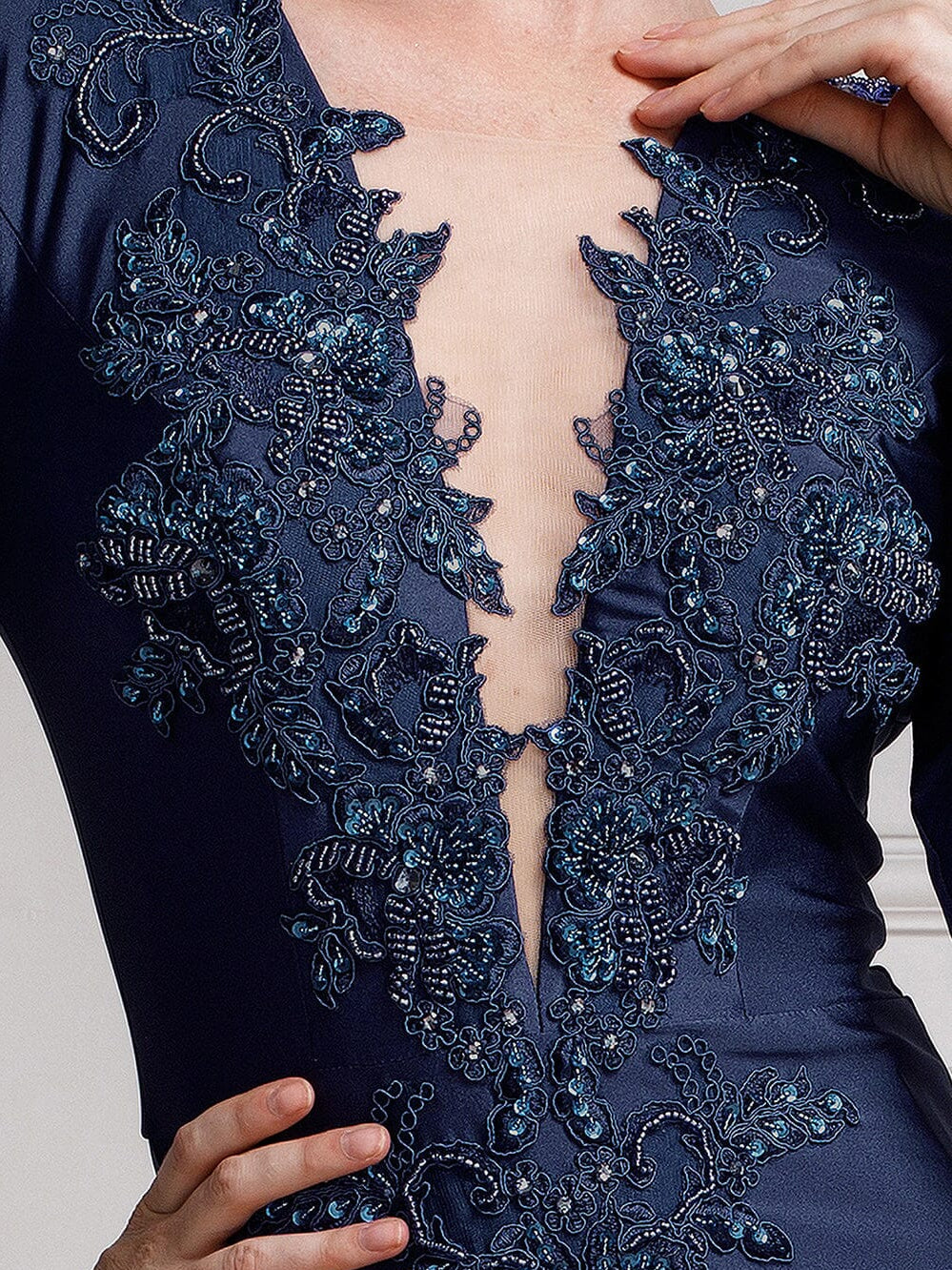 Navy blue formal dress bodice with intricate beaded floral embroidery and V-neck detail.