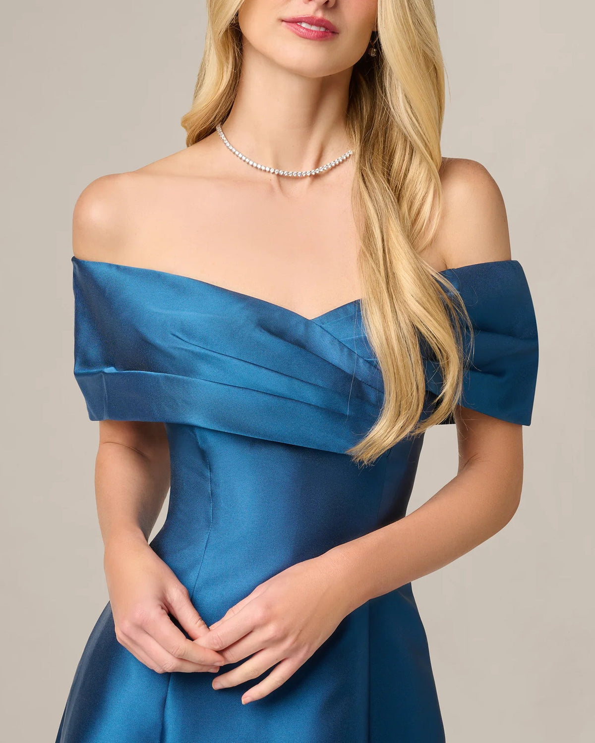 Close view of teal blue off-shoulder satin bodice with wrapped drape design