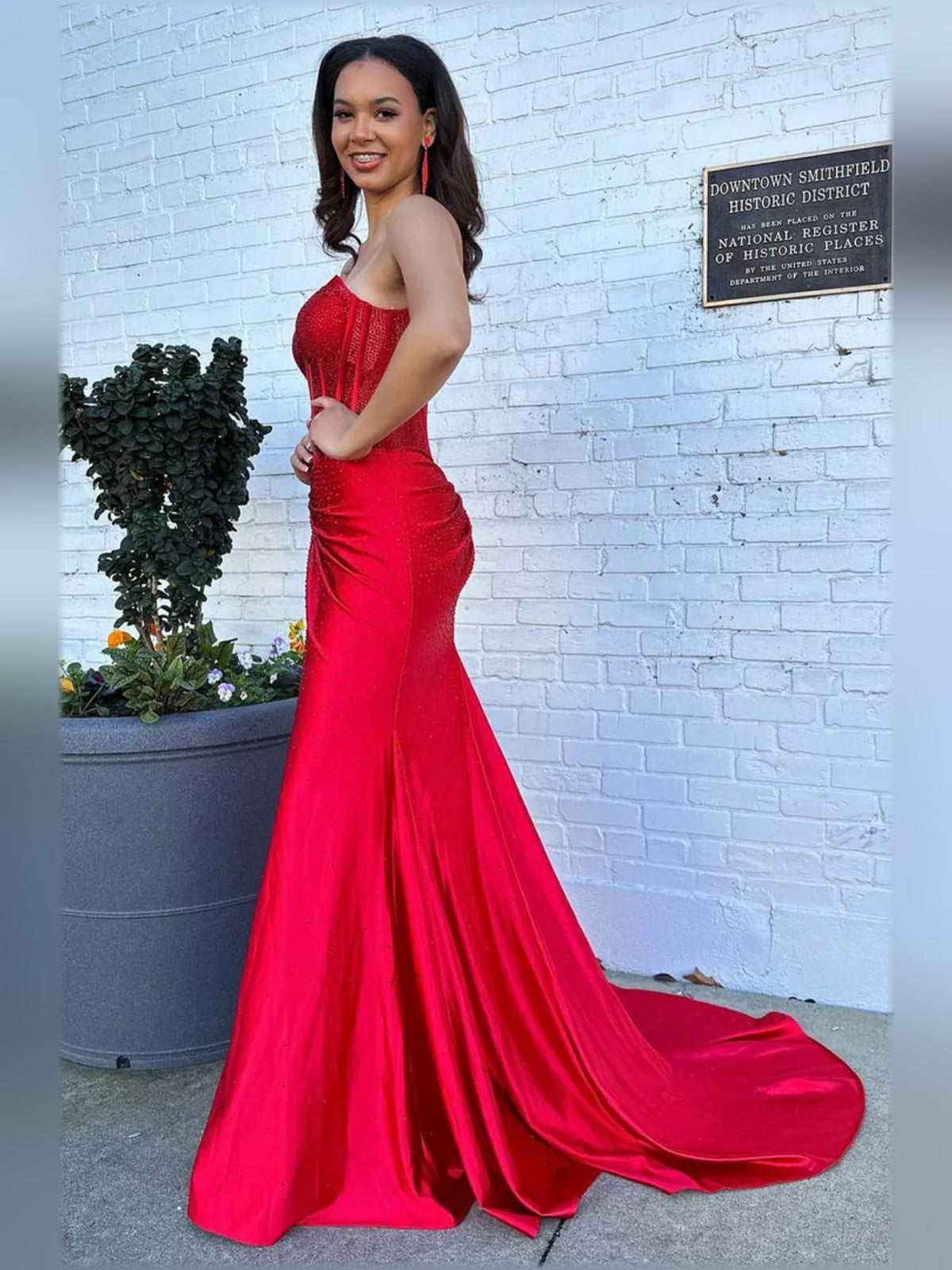 Red sweetheart corset formal dress with side train and long flowing skirt
