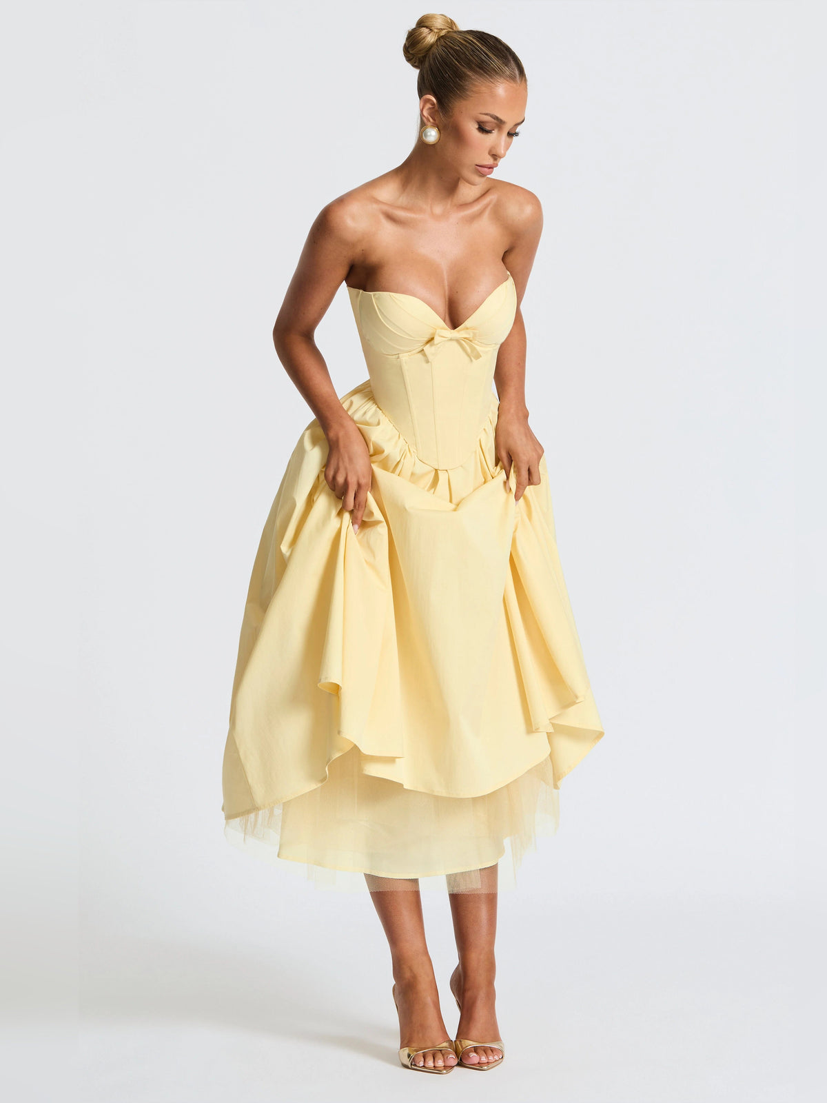 Lemon yellow strapless midi dress with sweetheart neckline, layered skirt, and bow at waist