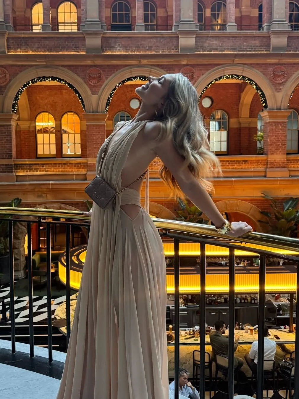 Champagne open-back maxi dress with halter straps and flowing drape