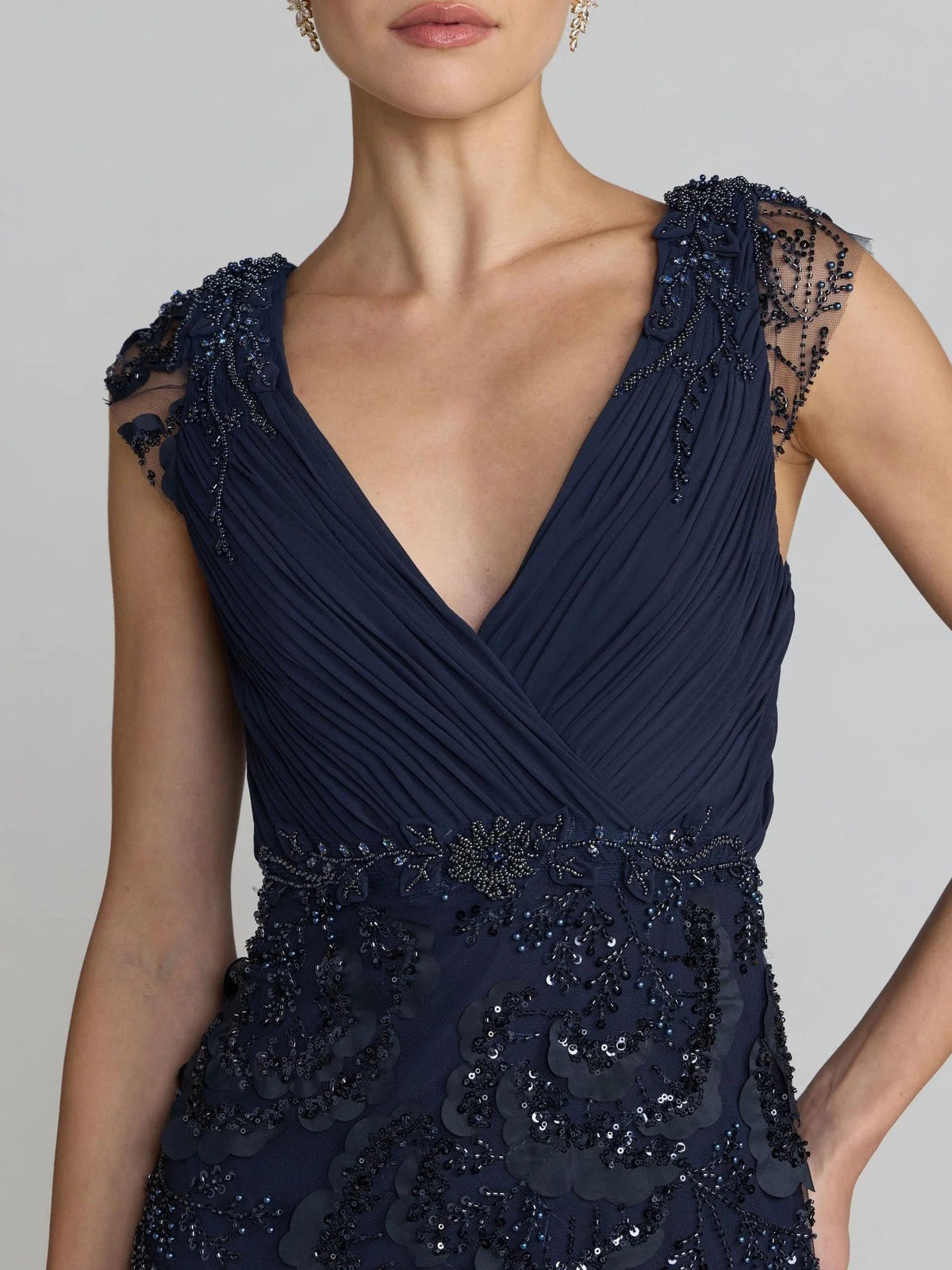 Dark blue sleeveless V-neck bodice with beaded floral appliques and pleated detail