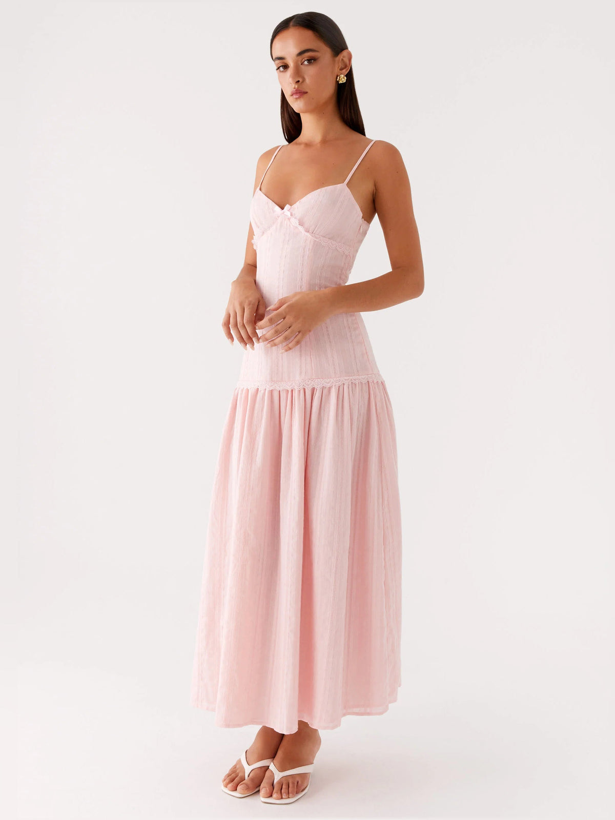 Pink midi formal dress with thin straps, fitted bodice, and tiered skirt