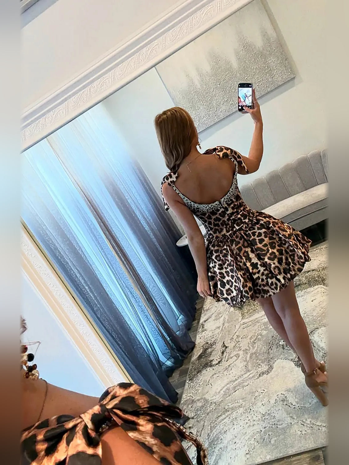 Back view of leopard satin mini dress with bow straps and crystal-studded bodice