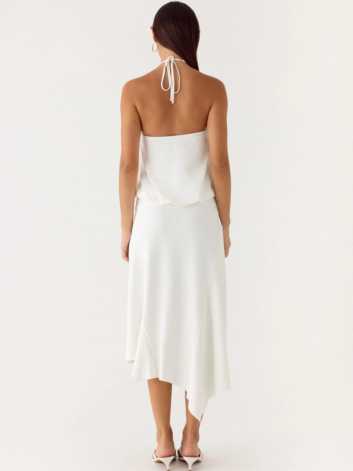 White midi formal dress with open back and halter tie, draped skirt, asym hem