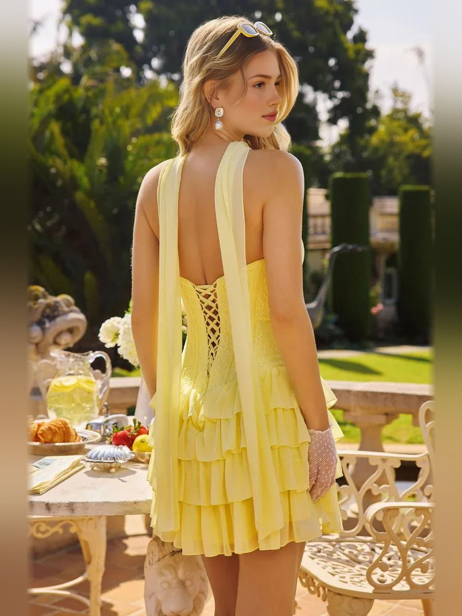 Yellow strapless mini dress with back cutout, corset bodice, and tiered ruffle hem