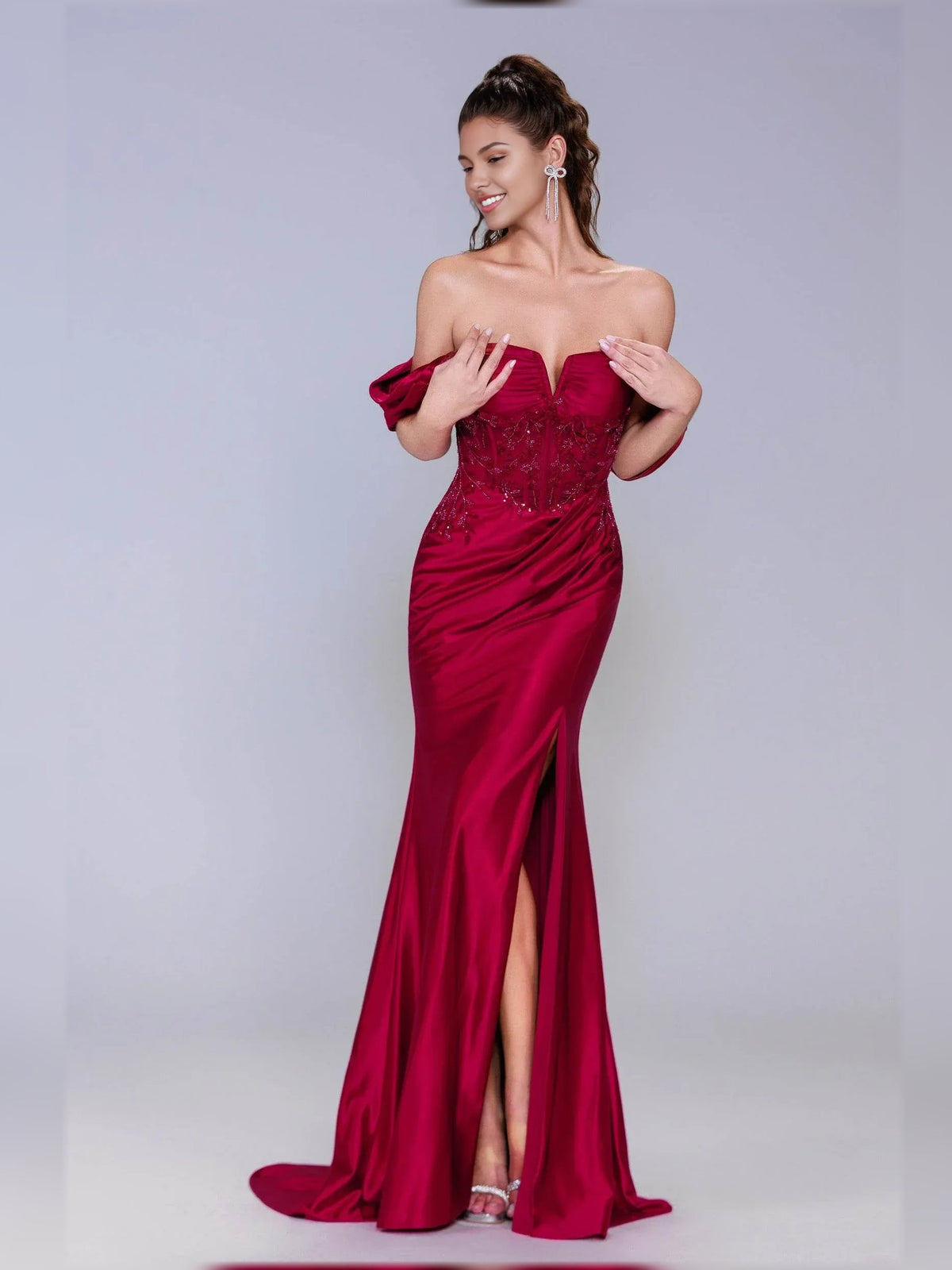 Deep red off-shoulder formal dress with embellished corset bodice and front slit.