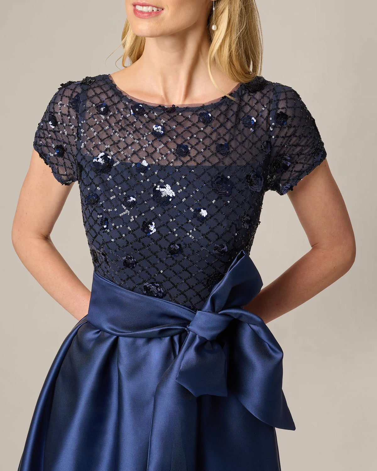Navy sequined bodice with cap sleeves and satin bow waist detail