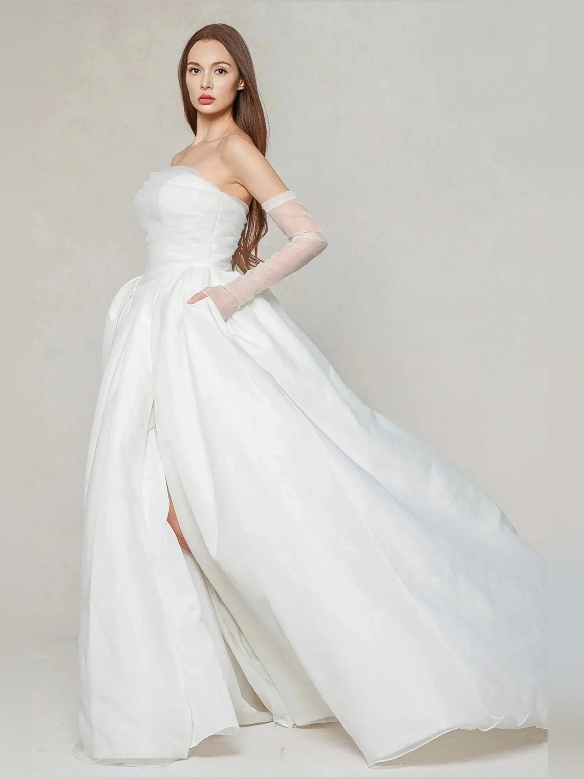Ivory strapless ball gown with gathered bodice, pleated skirt, and side slit