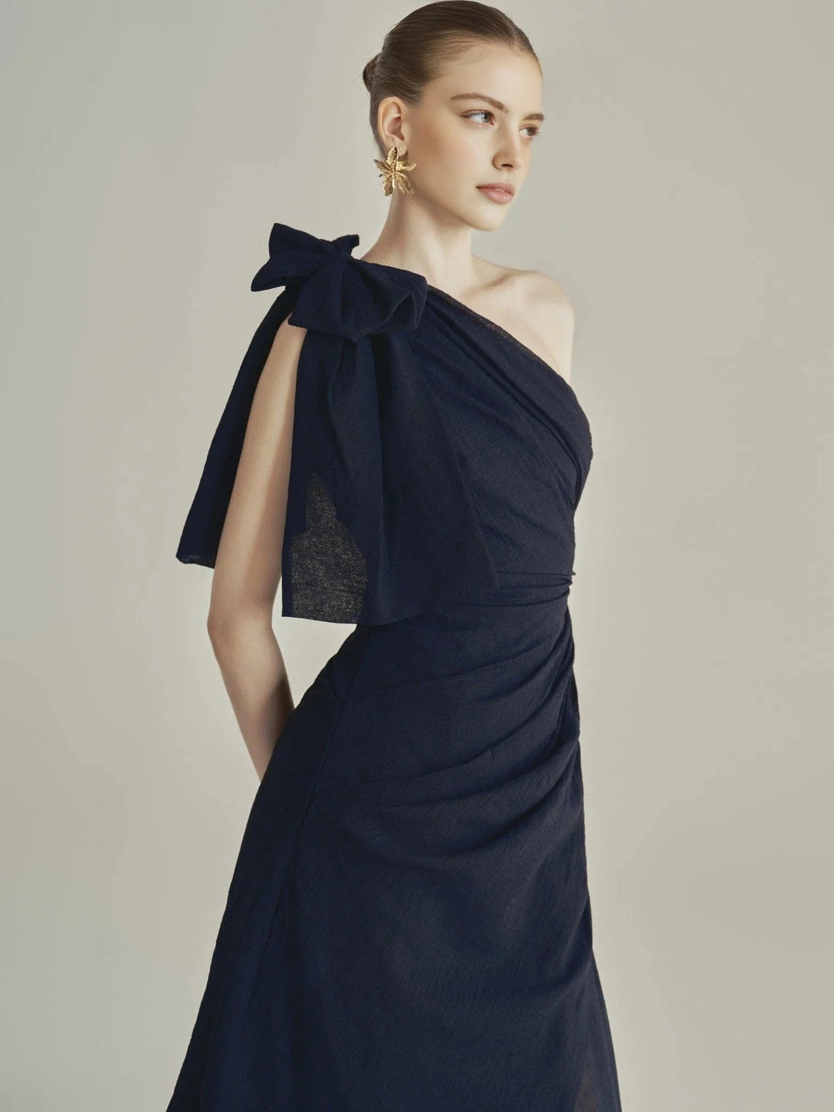 Dark blue one-shoulder ruched bodice dress with bow detail and layered skirt