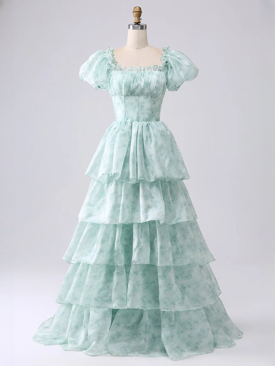 Mint green off-shoulder tiered corset A-line prom dress on mannequin, floor length.