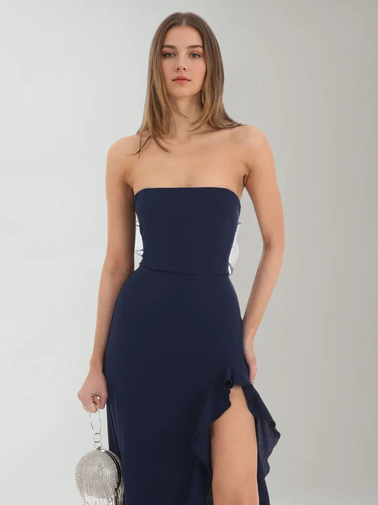 Dark navy strapless formal dress with ruched bodice and front slit, floor-length.