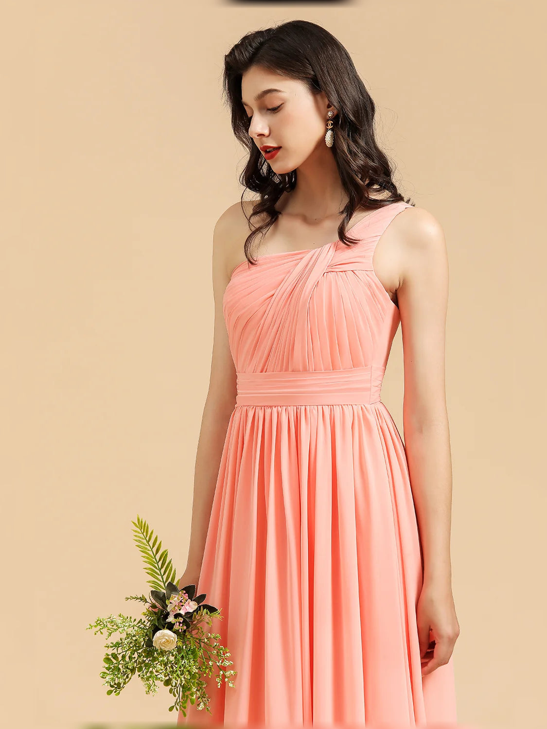 Coral one-shoulder pleated chiffon bodice and flowing A-line skirt, front detail.