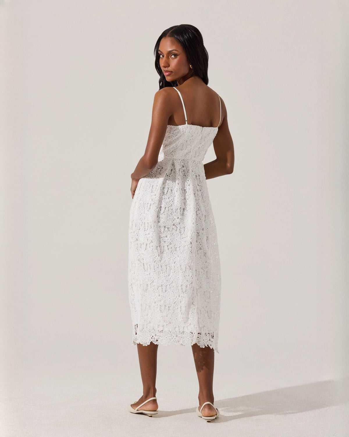 Back view of white sleeveless A-line midi dress with spaghetti straps and lace hem